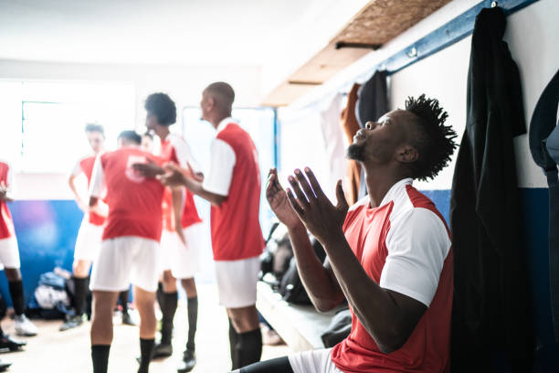 istock Soccer player praying before a match in the locker room 1398380313