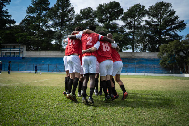 fußball-spieler feiern ein ziel - köpfe zusammenstecken stock-fotos und bilder