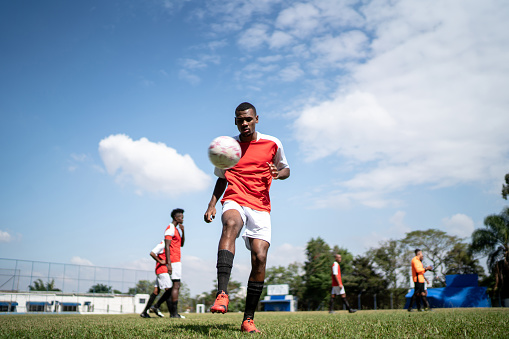 Soccer player doing kick ups on the field