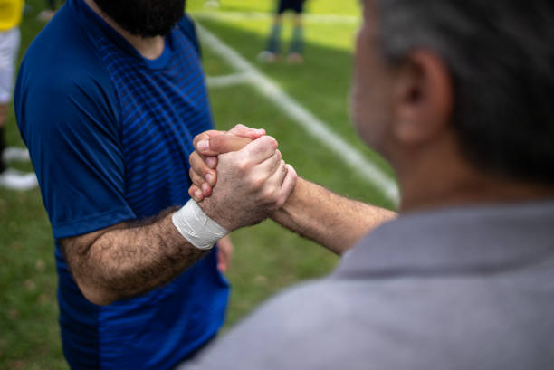 Soccer player and coach handshaking on the field