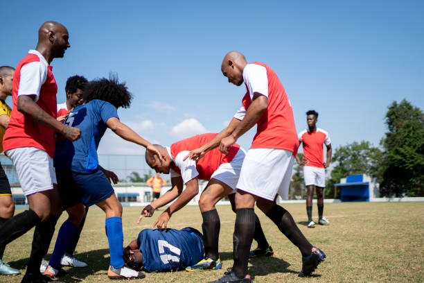 istock Soccer players arguing while one player is lying down on the field 1398380744