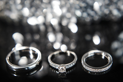 Solitaire diamond ring on black background.