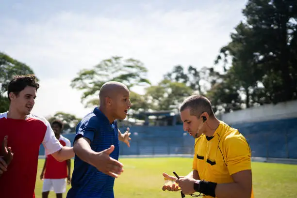 Soccer players complaining with referee during the match