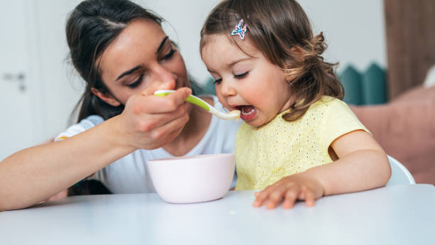 istock Mother feeding her girl 1398382763