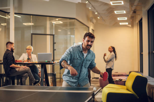 istock Young people playing table tennis in the office at work 1398382843