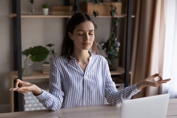 istock Peaceful calm woman meditating at office workplace with computer 1398385339