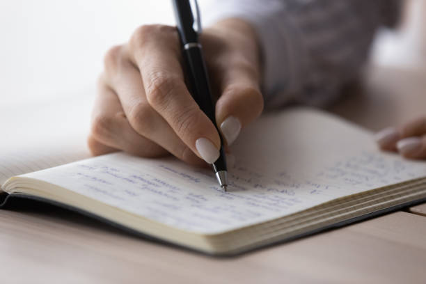 istock Office employee planning workday, writing list of tasks in notebook 1398385352