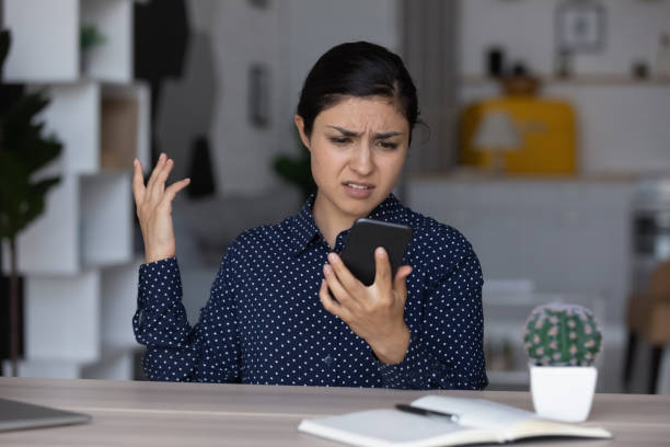 istock Upset annoyed Indian girl having problems with smartphone 1398385373