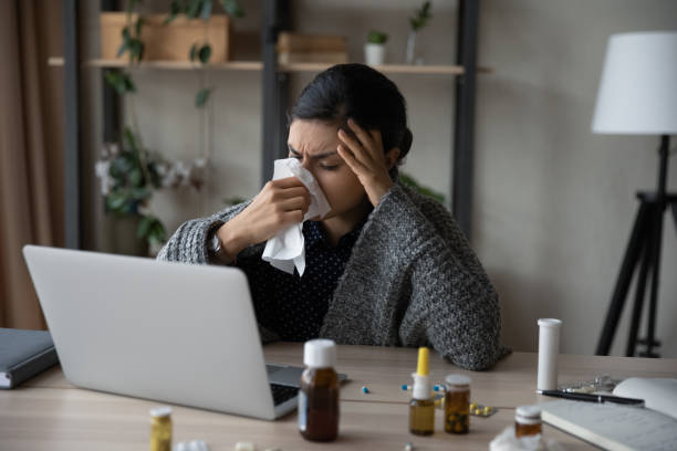 istock Sad sick Indian girl rubbing running nose with tissue 1398385400