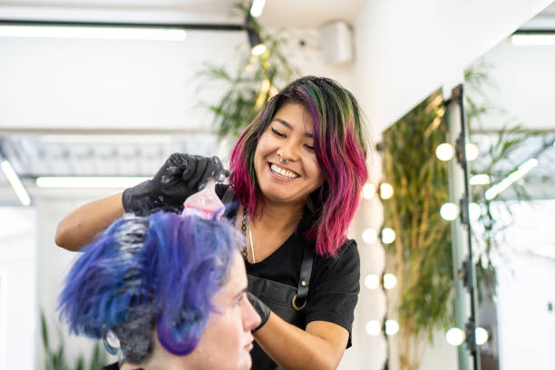 fryzjer farbujący włosy klienta w salonie fryzjerskim - barwiony wizerunek zdjęcia i obrazy z banku zdjęć