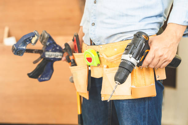 istock Handyman manual worker in tools belt and holding drill in his hands, Carpenter working with equipment in wood workshop, man doing woodwork in carpentry shop 1398389955