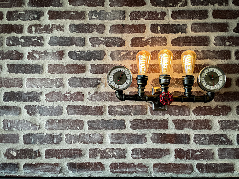 Edison Bulbs on a brick wall with clocks for gauges.