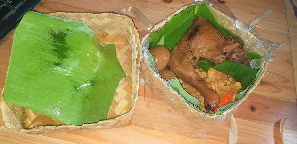 Indonesian traditional dish Gudeg Ayam, a traditional dish from Yogyakarta and Central Java, Indonesia. Gudeg in besek container made of woven bamboo pack with banana leaf, Krecek Fried Sambal tempeh, Pindang Egg and Chicken Indonesian traditional dish Gudeg Ayam, a traditional dish from Yogyakarta and Central Java, Indonesia. Gudeg in besek container made of woven bamboo pack with banana leaf, Krecek Fried Sambal tempeh, Pindang Egg and Chicken delicacies of Java island gudeg stock pictures, royalty-free photos & images