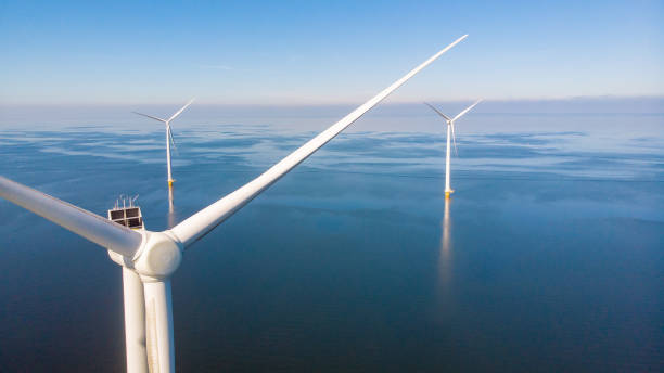 huge windmill turbines, offshore windmill farm in the ocean westermeerwind park , windmills isolated at sea on a beautiful bright day netherlands flevoland noordoostpolder - climate wind engine wind turbine imagens e fotografias de stock