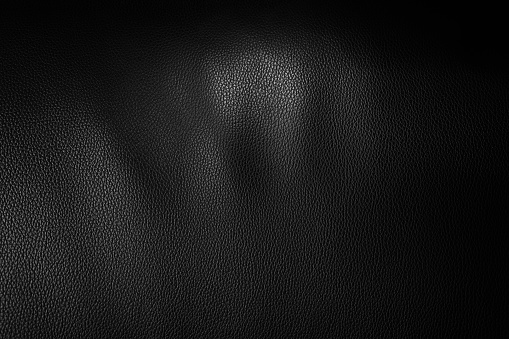 Abstract Textured Black leather with light for background.