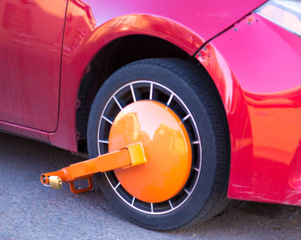 Parked Red Car with Orange Boot/Wheel Clamp stock photo