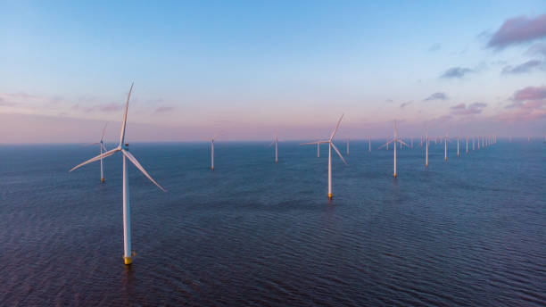 huge windmill turbines, offshore windmill farm in the ocean westermeerwind park , windmills isolated at sea on a beautiful bright day netherlands flevoland noordoostpolder - climate wind engine wind turbine imagens e fotografias de stock