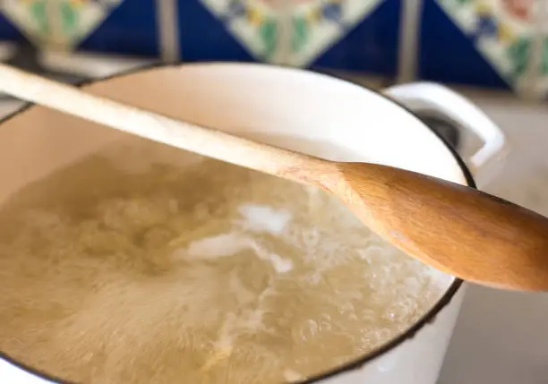 Photo of Pot of Boiling Water on Stove, Wood Spoon On Top