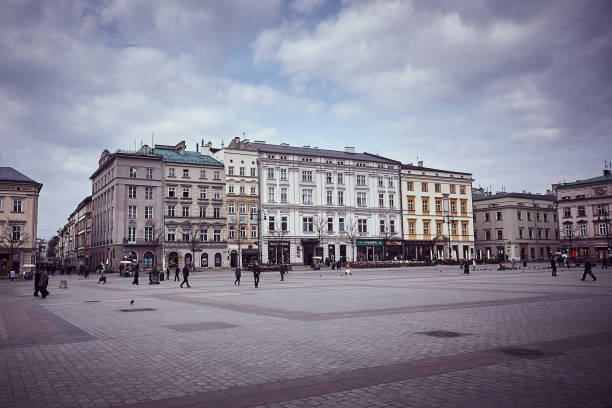 Krakow, Poland - March 18, 2014 : View of sidewalk cafe in old town while pedestrians pass by