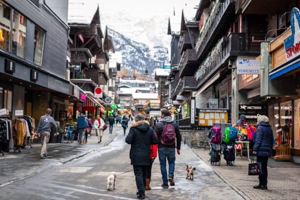 spacery turystów z psami na ulicy miasta w zermatt. - zermatt zdjęcia i obrazy z banku zdjęć