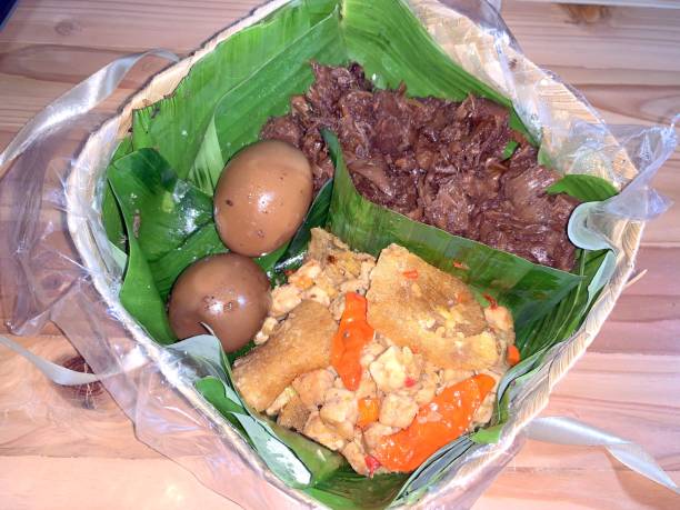 Indonesian traditional dish Gudeg Telor, a traditional dish from Yogyakarta and Central Java, Indonesia. Gudeg in besek container made of woven bamboo pack with banana leaf, Krecek Fried Sambal tempeh, Pindang Egg Indonesian traditional dish Gudeg Telor, a traditional dish from Yogyakarta and Central Java, Indonesia. Gudeg in besek container made of woven bamboo pack with banana leaf, Krecek Fried Sambal tempeh, Pindang Egg gudeg stock pictures, royalty-free photos & images