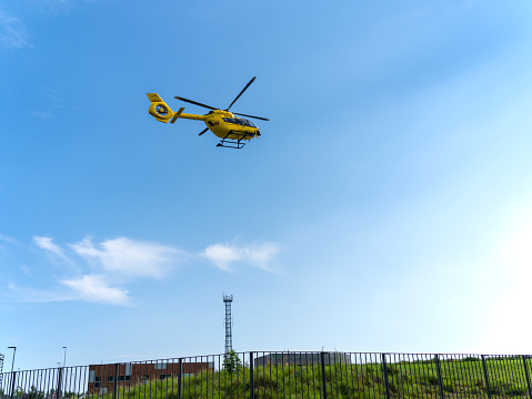 Bergamo, Italy. The rescue helicopter and emergencies landing at the hospital. Yellow medical helicopter. Air ambulance. Medical Air Assistance