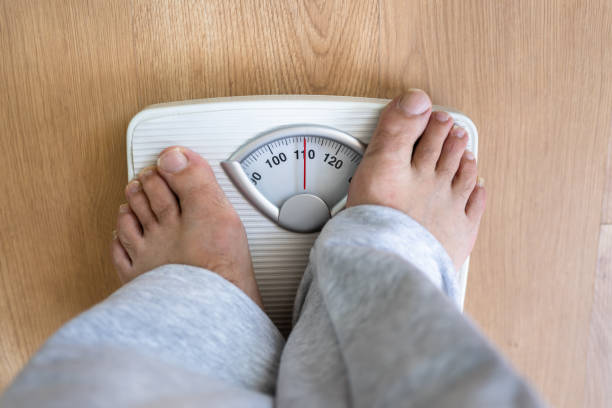 istock Person Standing On Weighing Scale 1398413010