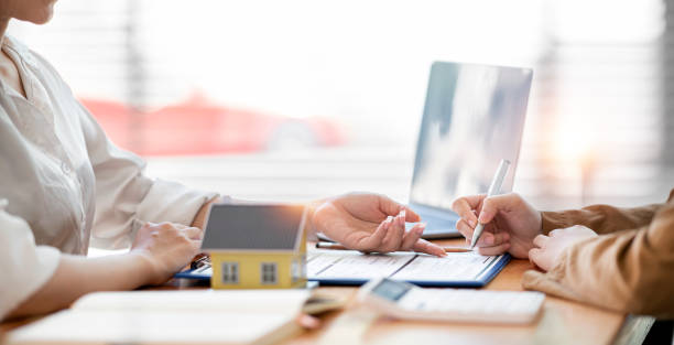 istock Real estate agent explaining and let customers sign a house purchase contract, discussing for contract to buy house, real estate concept and background. 1398413660
