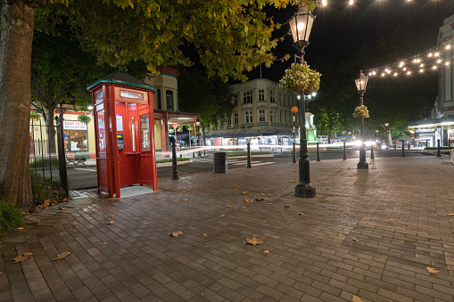 Whanganui New Zealand - April 9 2022; City downtown street scen at night with traditional red telephone boot,illumiated by street lamps.