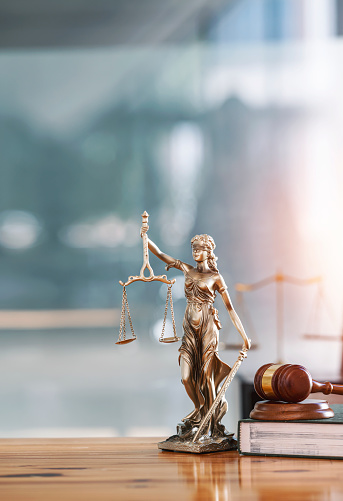 Legal and law concept. Statue of Lady Justice with scales of justice and wooden judge gavel on wooden table. Panoramic image statue of lady justice.