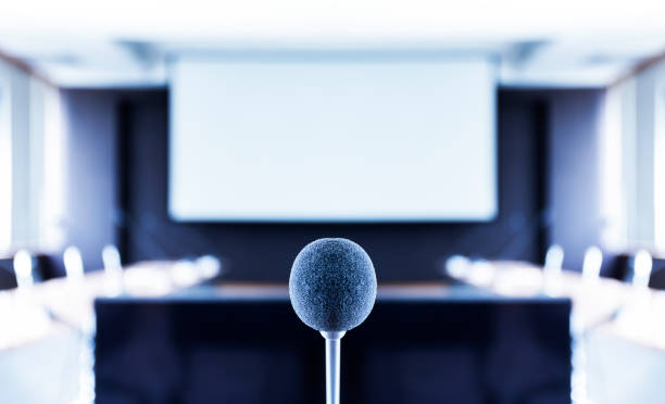 istock Microphone center of picture with screen projector background 1398417565