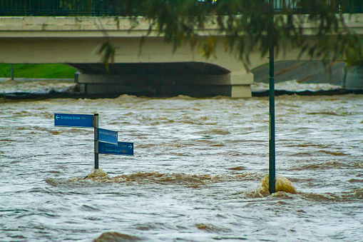 Local path sign surrounded by high floodwaters. Kedron Brook River, Brisbane.