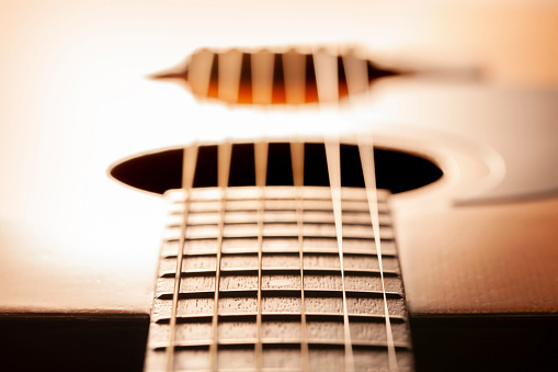 orange electric bass guitar on wood background with copy space