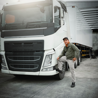 Asian Truck Driver Standing with Semi Trailer Trucks. Cargo Shipping Freight Truck Transport Logistics.