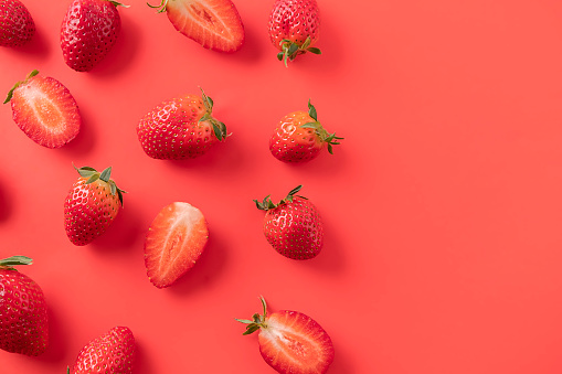 Strawberry background. Top view of raw strawberries on red background, copy space