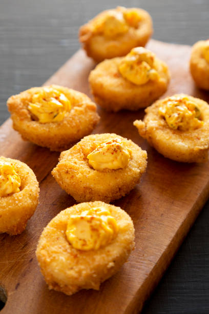 istock Homemade Deep-fried Deviled Eggs with Paprika on a Rustic Wooden Board, side view. 1398434444
