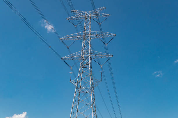 Power transmission towers and power lines under blue sky and white clouds