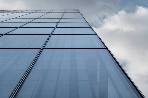 glass building facade under blue sky and white clouds