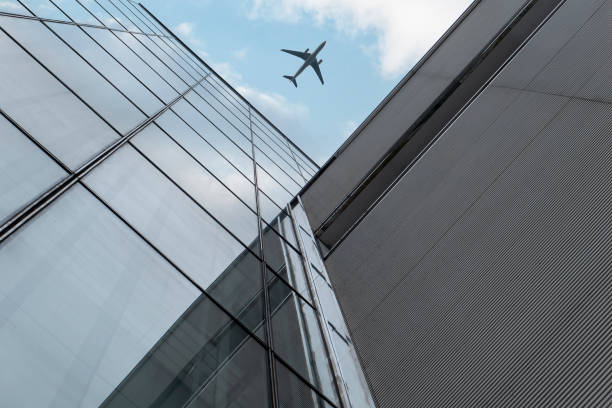 istock Airplane flying over modern buildings 1398440725