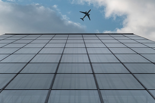 Airplane flying over modern buildings