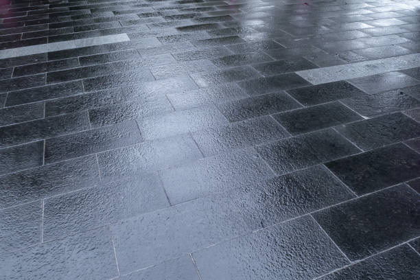 Square ground paved with wet floor tiles after rain