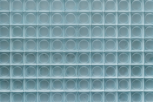 A wall of stacked cuboid glass bricks