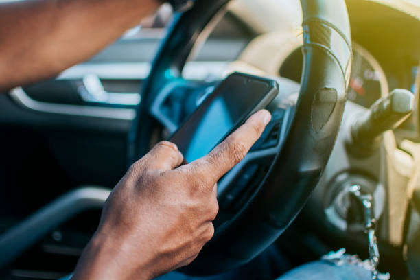 istock Close up of driver hands using his phone, Person in his car using cell phone, Concept driver hands touching cell phone screen 1398443546