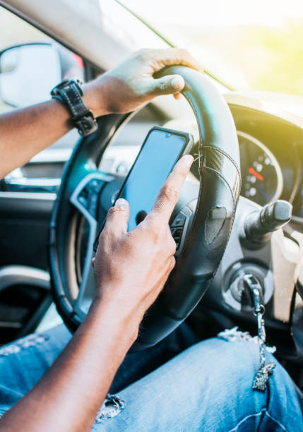 istock Close up of driver hands using his phone, Concept driver hands touching cell phone screen, Person in his car using cell phone 1398443552