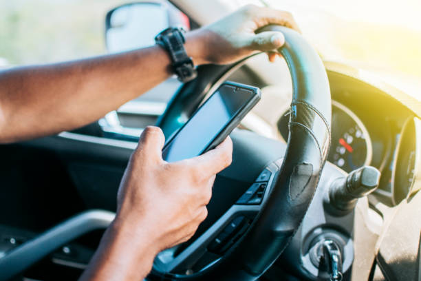 istock Person in his car using cell phone, Close up of driver hands using his phone, Concept driver hands touching cell phone screen 1398443557