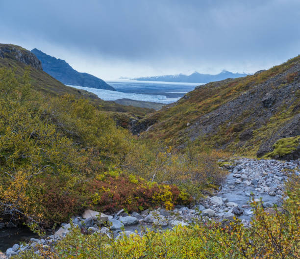 Beautiful autumn view from Mulagljufur Canyon to Fjallsarlon glacier with Breidarlon ice lagoon, Iceland. Not far from Ring Road and at the south end of Vatnajokull icecap and Oraefajokull volcano. hermosa vista de otoño desde el cañón mulagljufur hasta el glaciar fjallsarlon con la laguna de hielo breidarlon, islandia. no muy lejos de la carretera de circunvalación y en el extremo sur de la capa de hielo vatnajokull y el volcán oraefajokull.