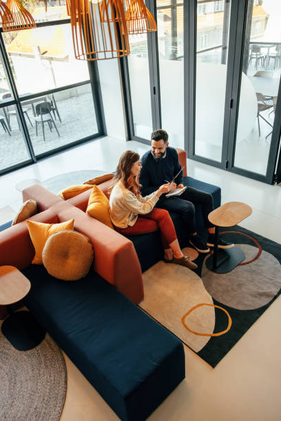 istock High angle view of two businesspeople working in a lobby 1398446316