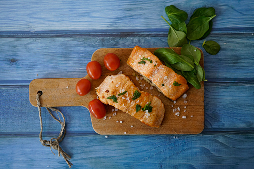 Baked salmon steak with tomato, baby spinach and radish