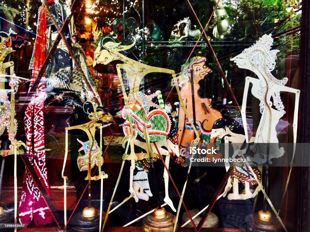 Balinese Shadow Puppets - Wayang Kulit Horizontal closeup photo of a variety of colourful handmade traditional shadow puppets made from painted buffalo hide in a store window display in Ubud, Bali. Craft Product Stock Photo