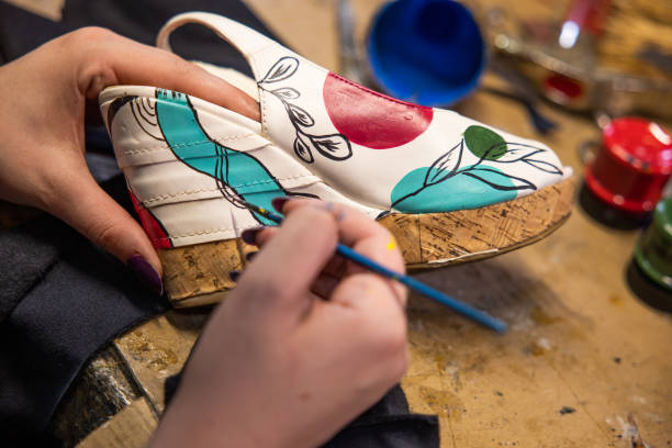 istock Unrecognizable female shoemaker painting the high heels 1398461195